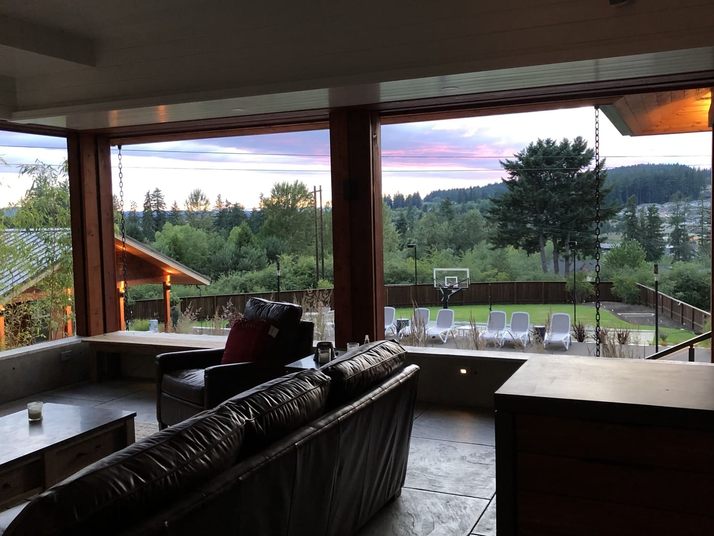 Covered outdoor living area with folding glass doors at sunset